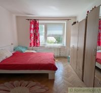 Hálószoba egy kétszobás lakásban ággyal, gardróbbal és fa dekorációjú padlóval.