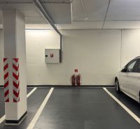 Földalatti parkolóhely jól látható jelzéssel és mellette egy fehér autó.
