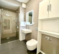 Fürdőszoba WC-vel, zuhanyzóval és tárolóhellyel egy kétszobás lakásban.