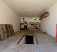 Garázsok szerelőaknával és tárolóhelyekkel, polcokkal és fa felületekkel.