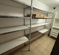 Tárolóhelyiség családi házban fém polcokkal és padlócsempével.