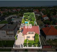 Családi ház a Malinovói Pozsonyi utcában, zölddel és szomszédos házakkal körülvéve.