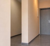 Folyosó egy családi házban, fa dekorációjú padlóval és semleges falakkal.