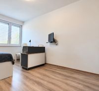 Hálószoba családi házban ággyal, asztallal és fa dekorációjú padlóval.