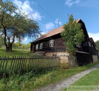 Fából készült ház Staškovban, amelyet fű és fák vesznek körül a kerítés mögött.