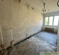 Üres szoba műanyag ablakkal és fedetlen radiátorokkal egy családi házban.