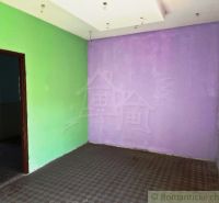 Lila és zöld fal az üzlethelyiségben, fa dekoros padlóval.