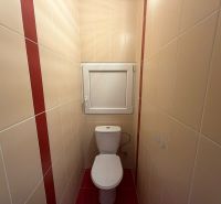 Fürdőszobai csempék egy háromszobás lakásban bézs és piros szín kombinációjával.