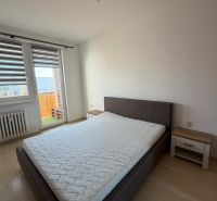 Hálószoba beépített szekrénnyel és fa dekor padlóval egy háromszobás lakásban.