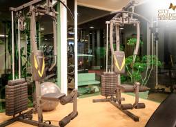 Fitnesz felszerelés a lakások építésében, zöld elemek, világítás és tükrös falak.