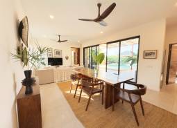 Belső tér étkezőasztallal, fa dekorációjú padlóval és nagy üvegajtókkal, házépítés.