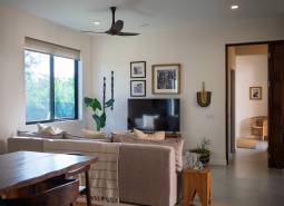 Belső tér kanapéval, televízióval és fa bútorokkal egy épülő házban.