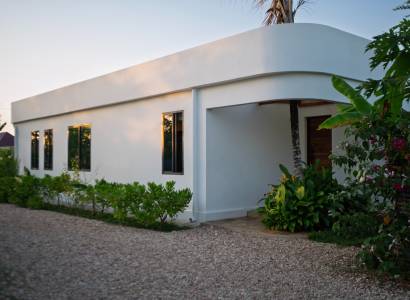 Házak építése Paje-ben, Unguja déli régiójában, zöld területtel a fehér épület körül.