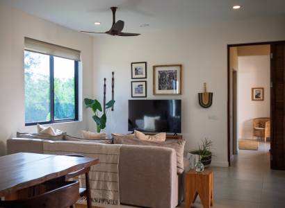 Belső tér kanapéval, televízióval és fa bútorokkal egy épülő házban.