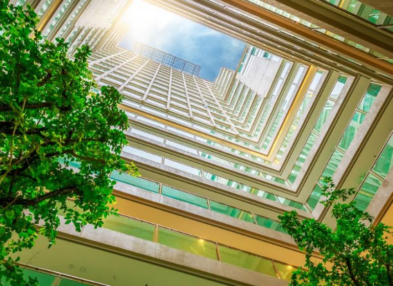 Kilátás az átriumból a lakásépítésre, a 1BCR Real Estate Group logójával.