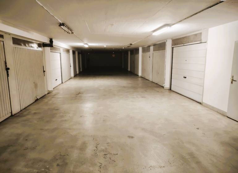 Belső parkológarázsok zárható kapukkal és betonpadlóval.
