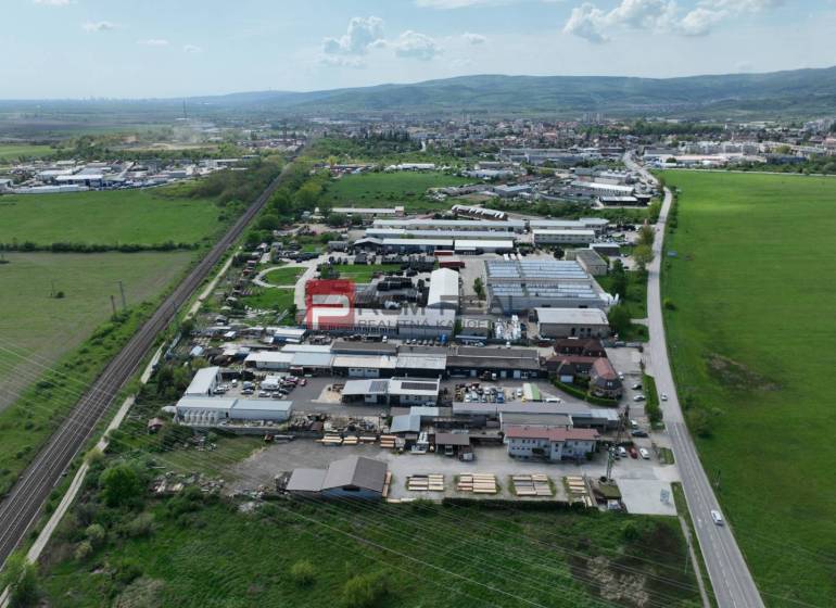 Légi felvétel a természet által körülvett üzleti területekről a Pezinok-i Šenkvická úton.