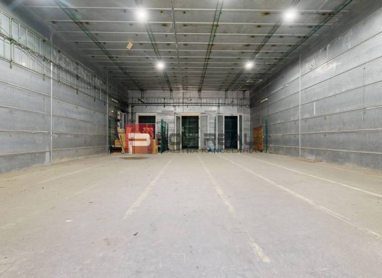 Sklady és csarnokok: Üres belső tér magas mennyezettel és világítással.