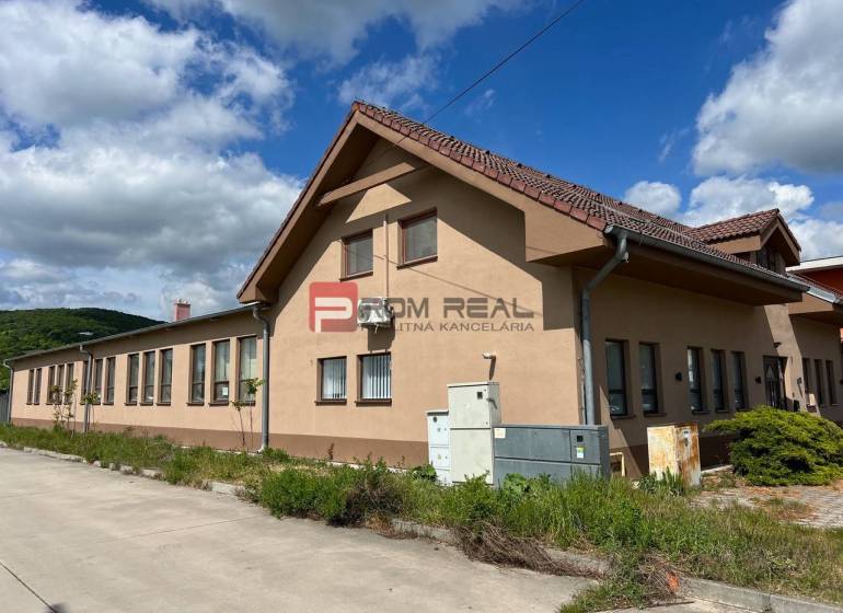 Gyártóhelyiségek a Pozsony III. kerületében, az Új utcában, kék égbolttal és zölddel.