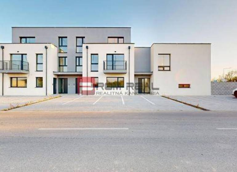 Épület a Bottova utcán, modern építészet, parkoló és családi ház a háttérben.