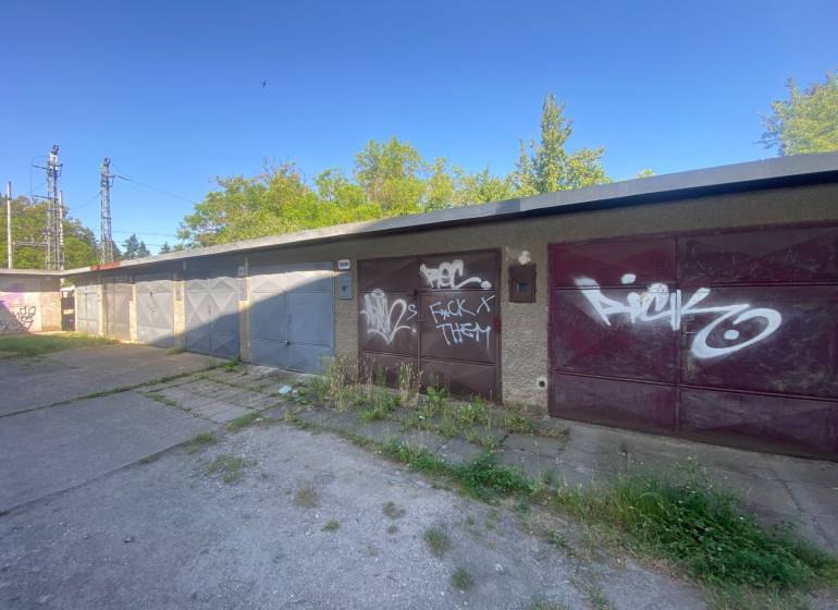 Garázsok Zólyomban, graffiti a kapukon, zölddel és betonfelülettel körülvéve.