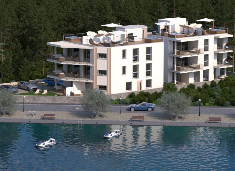 Modern épület a vízfelület mellett, zölddel és pálmafákkal körülvéve, parkolóval.