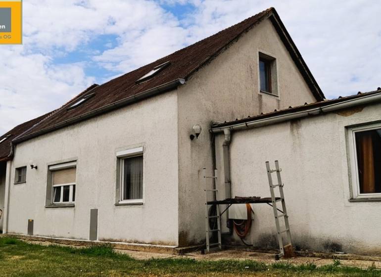 Családi ház Potzneusiedl városában, egyszerű homlokzattal és nyeregtetővel.