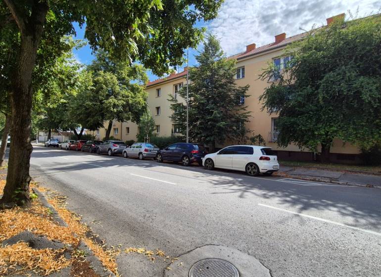 A Párovcami alatt Pöstyénben fák szegélyezik az utat a háromemeletes bérházak mellett.