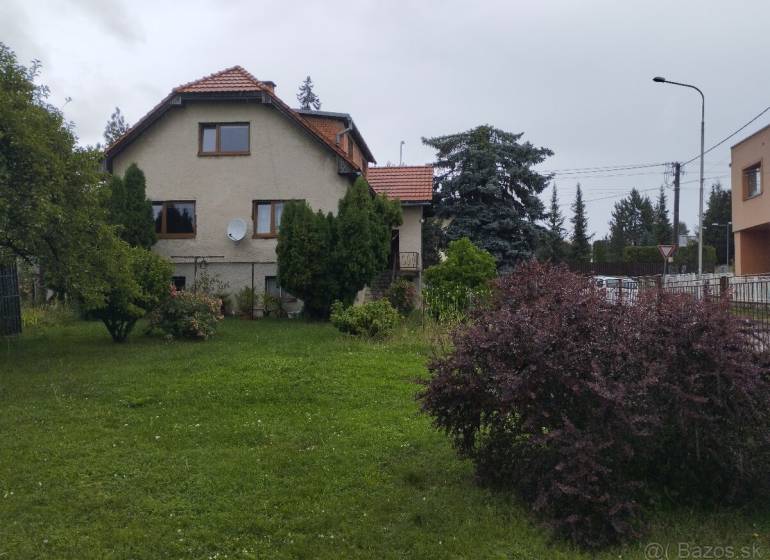 Családi ház Martinban, rendezett kerttel, fákkal és bokrokkal körülvéve.