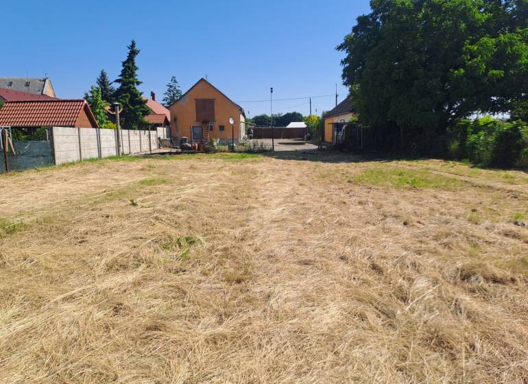 Családi ház kertje Galántán, rendezett gyeppel és kerítéssel.