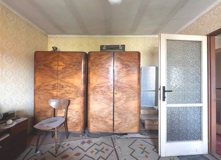 Retro bútor háromszobás lakásban fa szekrényekkel, szőnyeggel és tapétákkal.