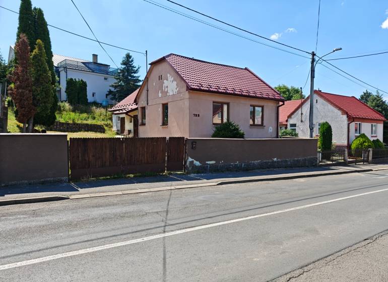Családi ház Vranov nad Topľou-ban, a Dlhá utcában, piros tetővel és fa kerítéssel.