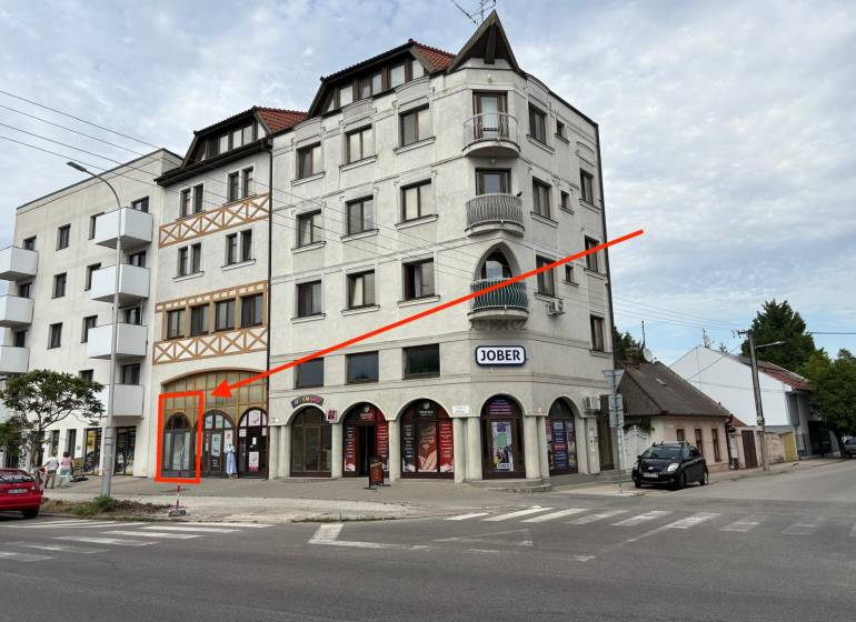 Az épület a Komáromi Petőfi utcában, földszinti üzlethelyiségekkel.