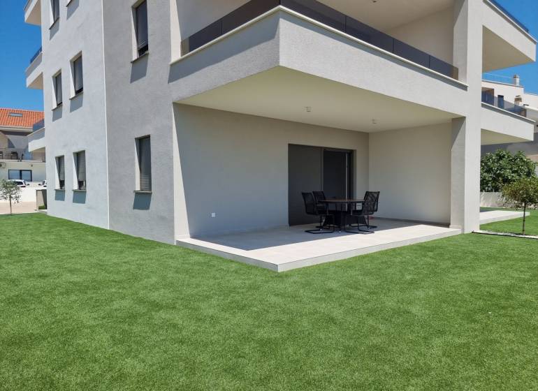 A Vodice-i 4 szobás lakás külseje modern terasszal és zöld gyepfelülettel.