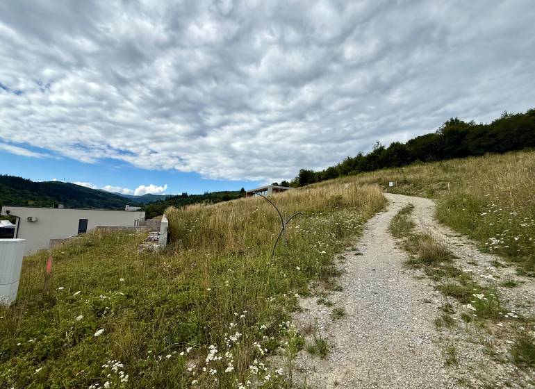 Lakóingatlanok Divinkában vidéki úttal és panorámás kilátással a tájra.