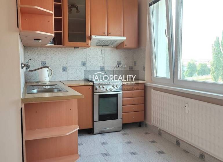 Konyha egy 4 szobás lakásban fa szekrényekkel és nagy ablakkal.