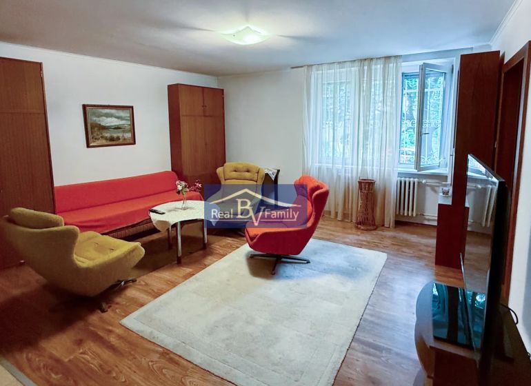 Nappali egy kétszobás lakásban retro bútorokkal és fa dekorációjú padlóval.