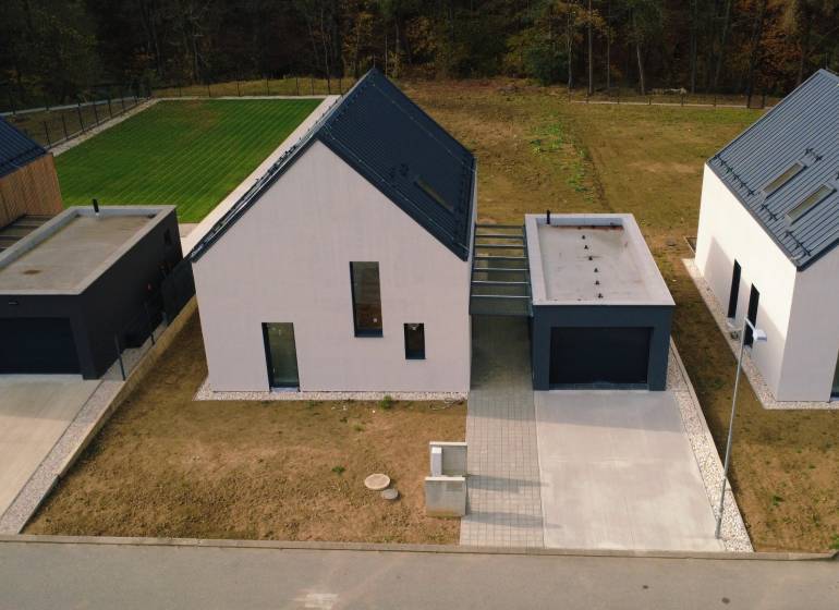 Családi házak a Pod Drieňovou utcában, Kamenica nad Cirochou-ban, gyep és bevezető út által körülvéve.