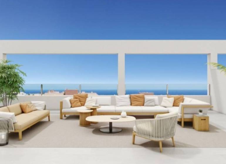 A torreviejai nyaraló apartman terasza ülőhellyel, háttérben az óceán és a kék ég.