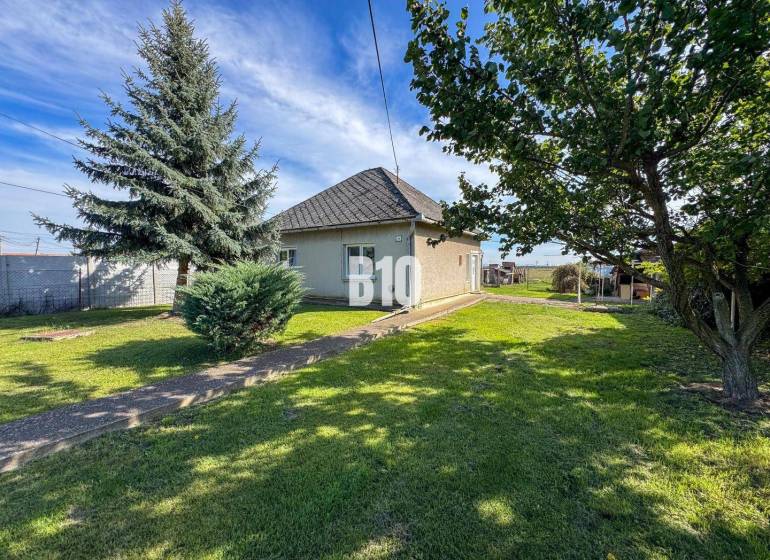 Családi ház Ondrejovceban, amelyet zöld gyep és fák vesznek körül a tágas kertben.