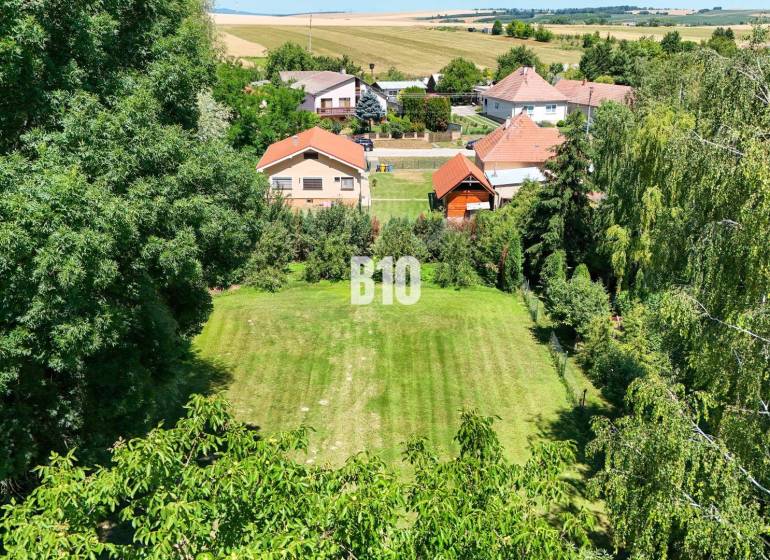 Kert zölddel és családi házakkal körülvéve Újszádon.