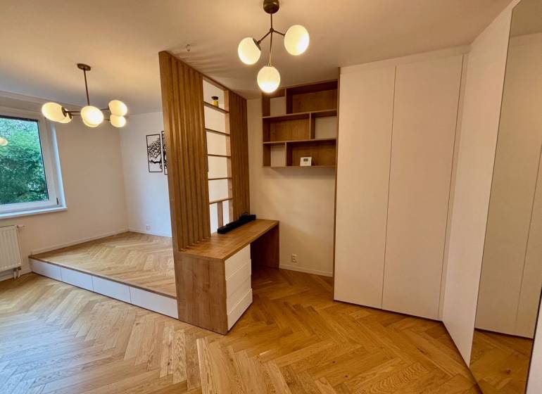 2 szobás lakás belső tere fa dekor padlóval és minimalista világítótestekkel.