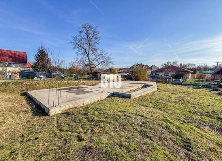 Építési telek beton alapokkal és zöldterülettel, ideális lakhatásra.