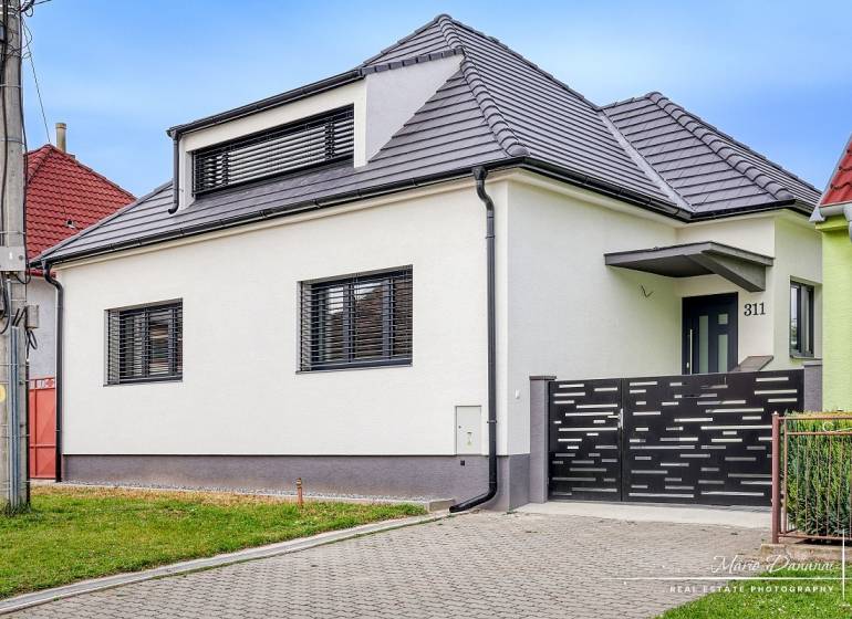 Családi ház Diófa utcában, Jaslovské Bohunicében, modern tetővel és kerítéssel.