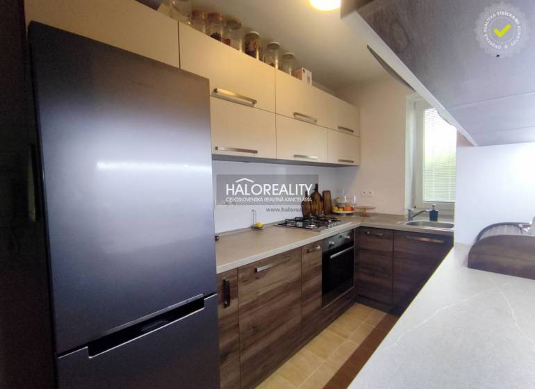 Konyha egy háromszobás lakásban, fa dekor padlóval és modern készülékekkel.