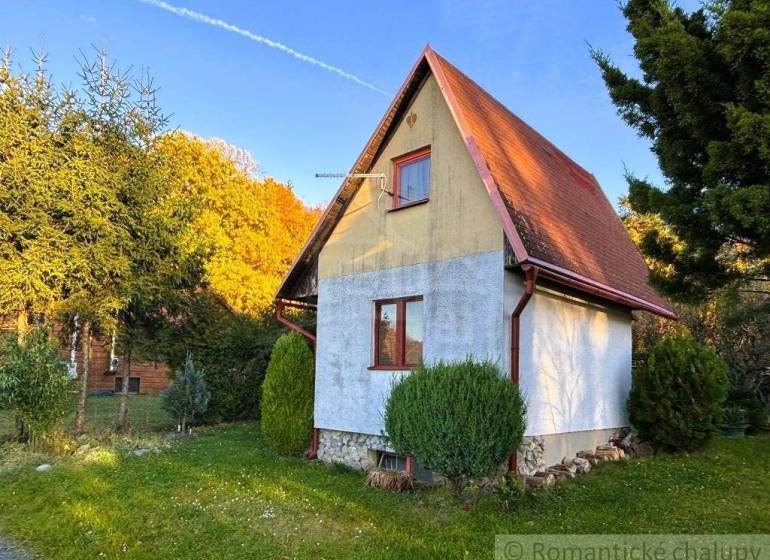 Ház Sološnicában, zölddel körülvéve, nyeregtetővel és gondozott gyepfelülettel.