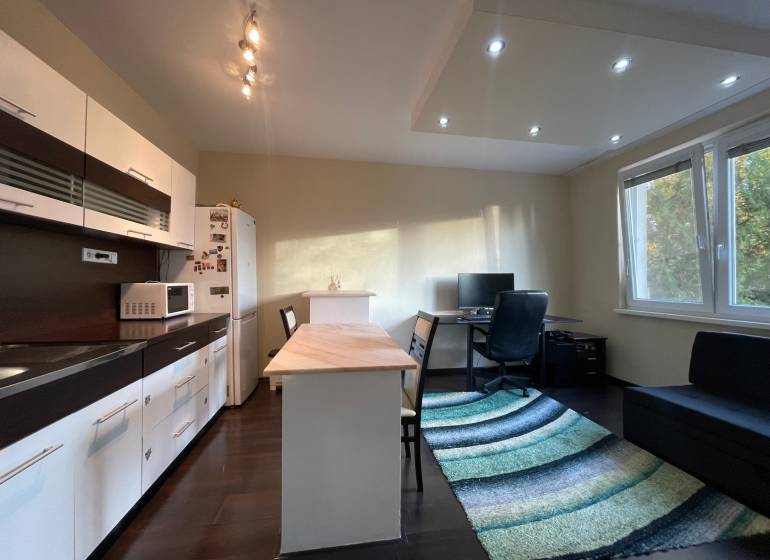 Konyha egy egyszobás lakásban fa dekor padlóval és dolgozósarokkal.