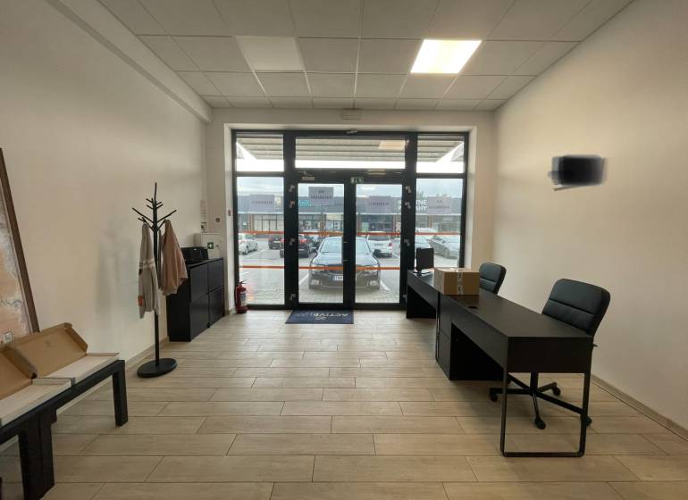 Kereskedelmi helyiségek belső tere bútorokkal és fa dekorációjú padlóval.