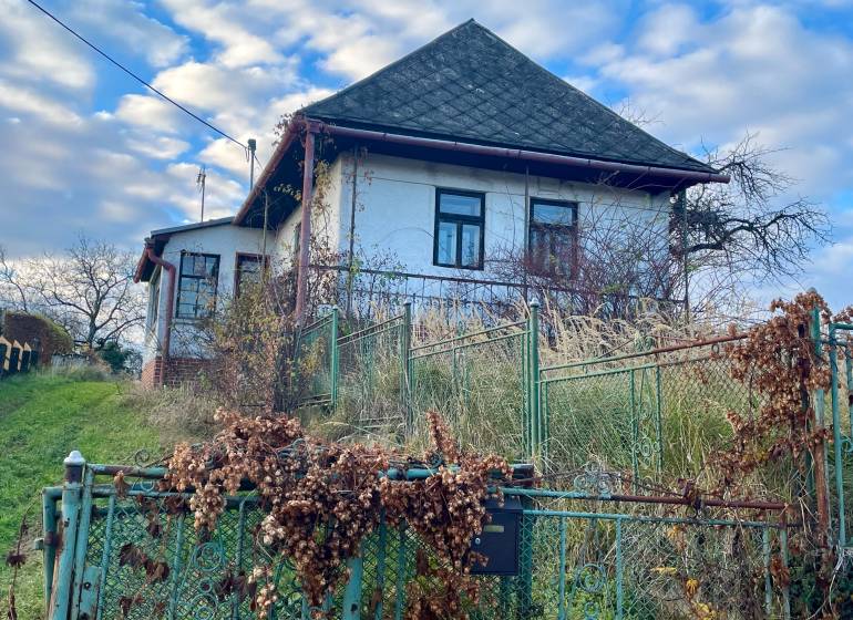 Családi ház a Fő utcán Felsőremetén, fém kerítéssel és kerttel.