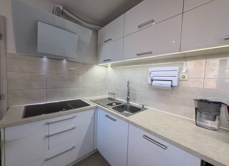 Beépített főzőlappal és mosogatóval ellátott konyha egy háromszobás lakásban.